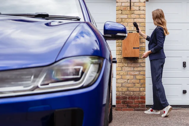 Woman charging an electric car at a home station, promoting sustainability. How apartment EV charger safety escalation records work