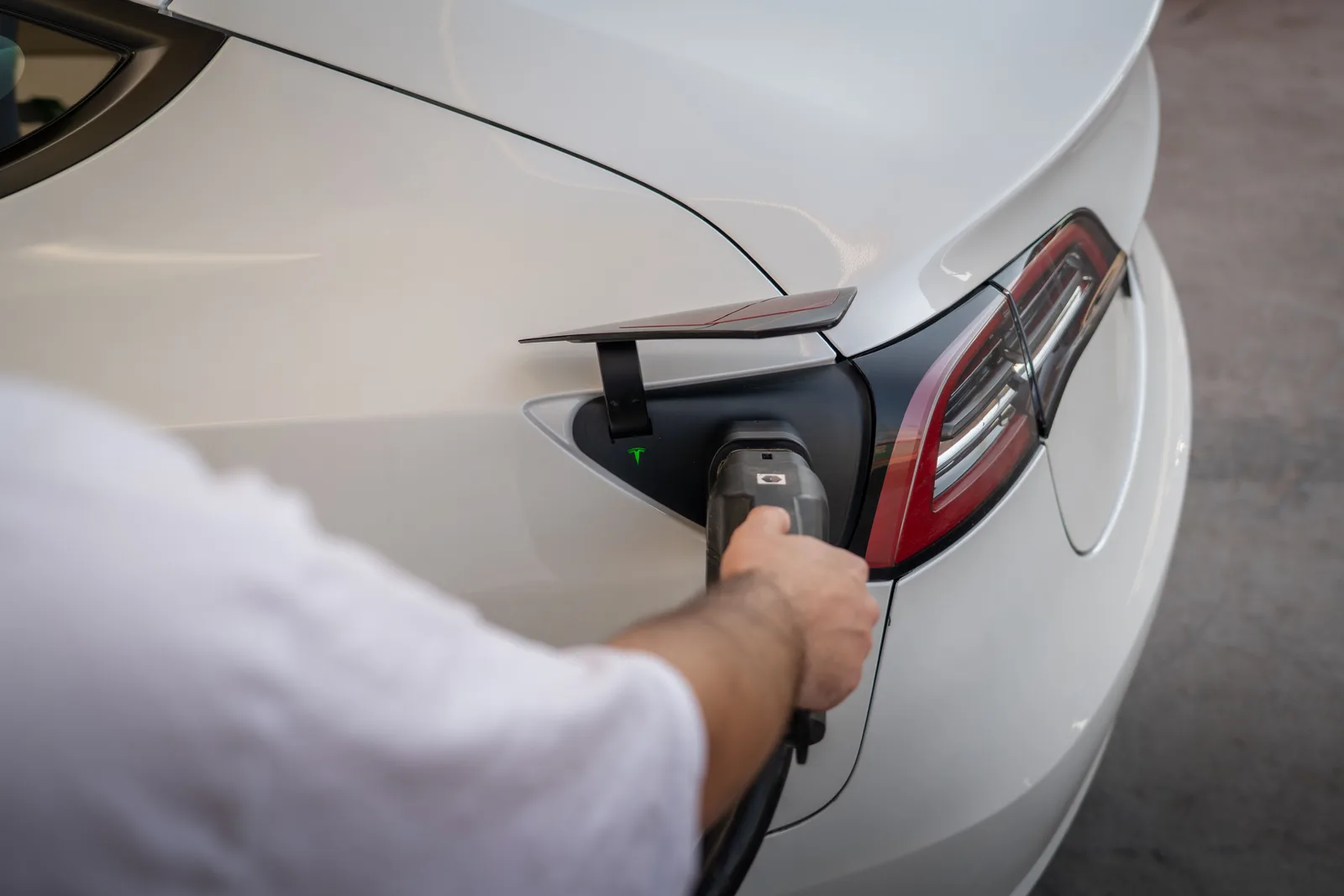 Close-up of an electric car being charged, emphasizing modern sustainable technology. Apartment EV charger serial number: recording each label reading
