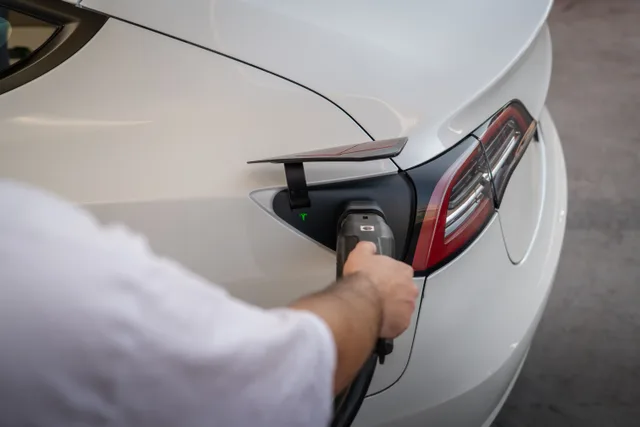 Close-up of an electric car being charged, emphasizing modern sustainable technology. Apartment EV charger serial number: recording each label reading