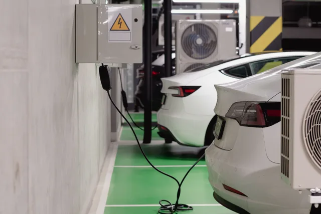 Electric vehicles charging at an indoor station in a modern underground garage. How to write an apartment EV power sharing rule residents can follow