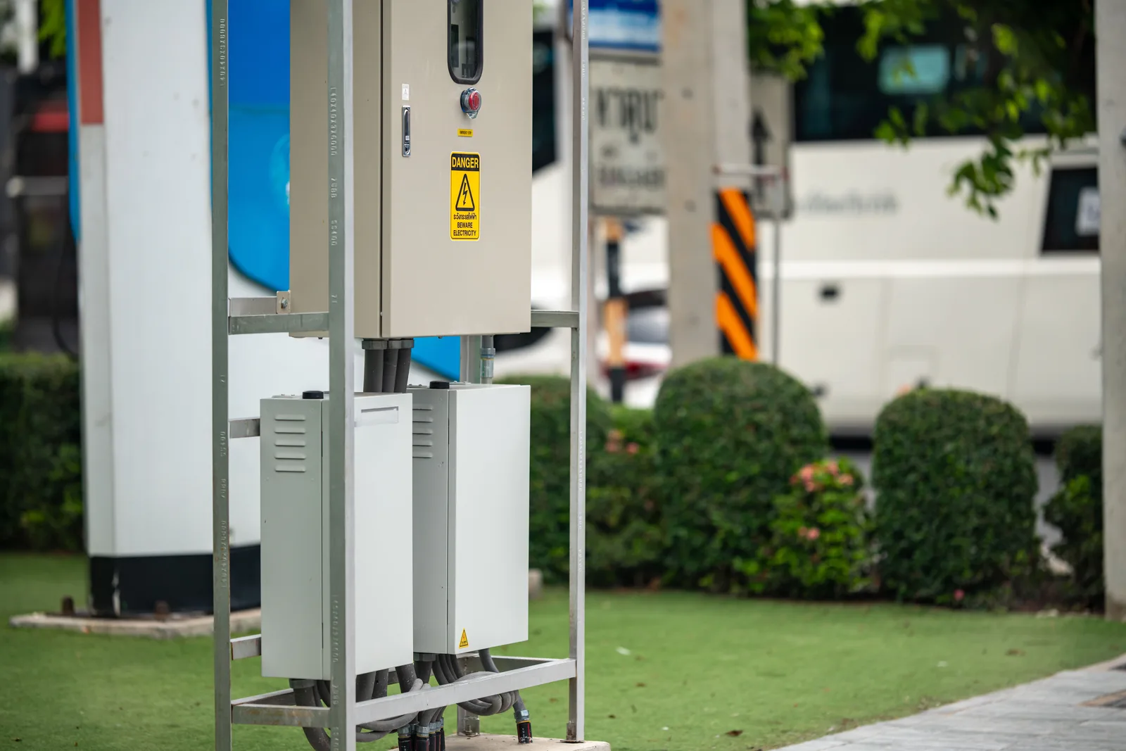Modern electric vehicle charging station with greenery in an urban setting. A multifamily EV charging roadmap: seven phases from baseline to annual review