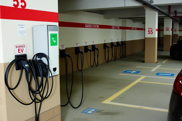 Row of shared EV charger plugs in a condo parking garage. Shared charging station designs: options compared